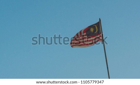 Malaysia national flag sky background at sunrise with golden light on flag