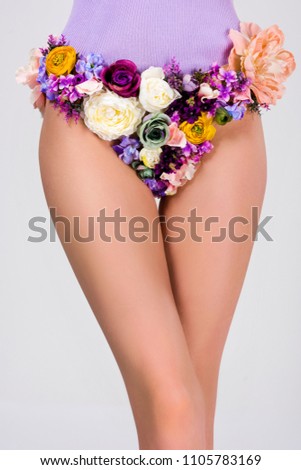 cropped shot of young woman in panties made of beautiful tender flowers isolated on grey 