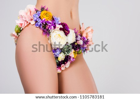 cropped shot of young woman in panties made of flowers isolated on grey