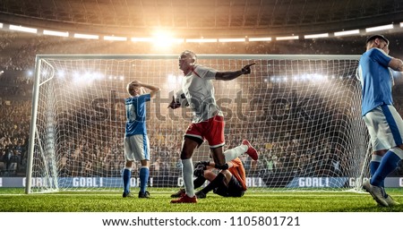 Attacker scores a goal, sending a ball past defenders and a goalkeeper on a professional soccer stadium. Stadium and crowd are made in 3D. Royalty-Free Stock Photo #1105801721