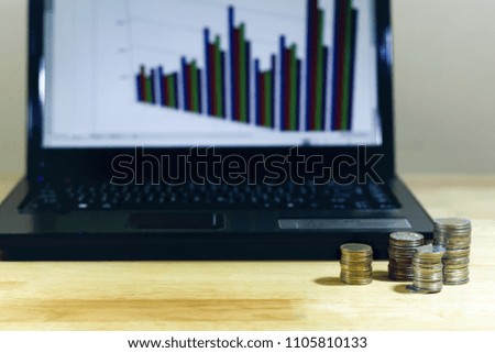 on the wood table there are money and silver coins, calculators, notebooks with graphs, savings ideas, and retirement investments