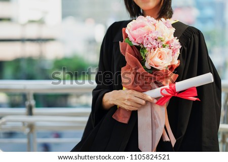 Happiness graduation day concept, woman graduate hand holding diploma and flower bouquet. Royalty-Free Stock Photo #1105824521