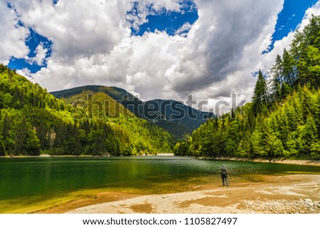 Professional photographer making a picture of a mountain lake