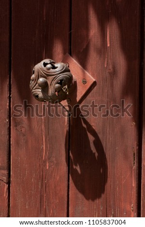 decorative, wrought iron handle on heavy wooden door, with shade