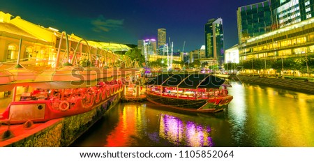 Scenic Clarke Quay Riverside area with cruise docked at pier in Singapore, Southeast Asia at dusk. Waterfront skyline reflected on Singapore River. Popular attraction for nightlife. Royalty-Free Stock Photo #1105852064