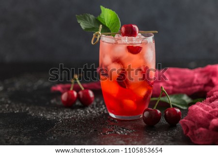 Fresh cherry cocktail. Fresh summer cocktail with cherry and ice cubes. Glass of cherry soda drink on dark stone background. Royalty-Free Stock Photo #1105853654