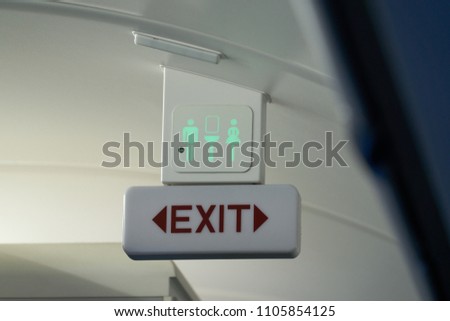 Exit seat belt and toilet sign on a flight.