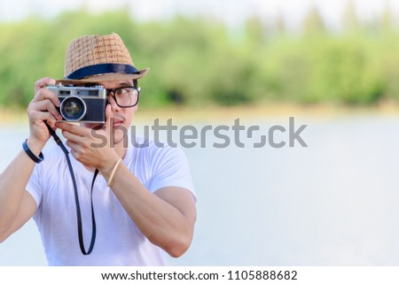 Young man is photographed with an ancient camera.