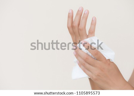 Woman cleaning her hands with a tissue. Healthcare and medical concept.