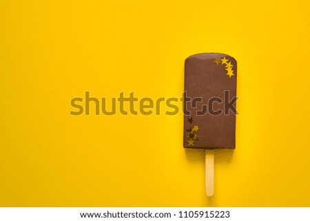 Summer holiday or non-organic food concept. Woman hand holding paper chocolate ice cream stick. Origami. Paper craft.  Copy space