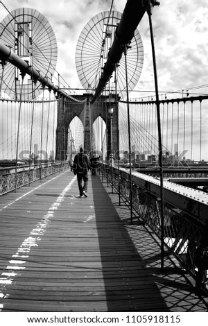 Black and white picture of the Brooklyn bridge with a leaving man