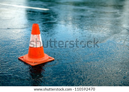 Traffic cone Traffic cone in the road on a rainy day