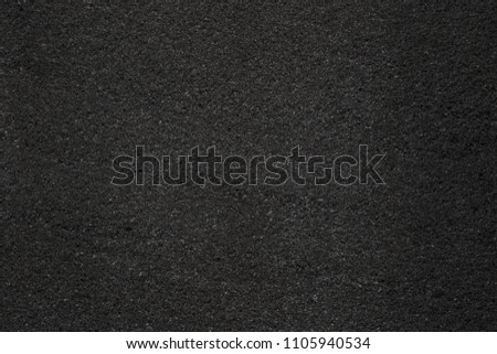 Asphalt with fine grain texture. Close-up of black road background. Top view of the rough surface