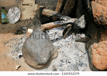 A well exposed image of an open first fire composed of rocks, ash and charcoal.