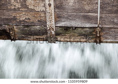 detail at small Wooden dam on a mountain river .