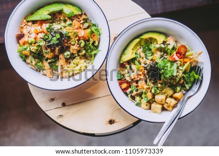Two green Goddess Buddha Bowls on wooden table. Healthy eating, food photography concept. Flatlay, horizontal