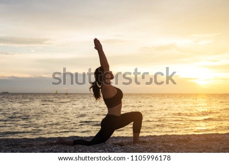Young healthy woman practicing yoga on the beach exercise at sunset time. healthy concept.