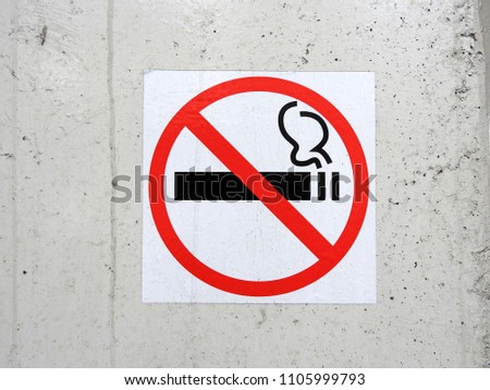 
The sign-smoking is prohibited, pasted on a white uneven wall.					