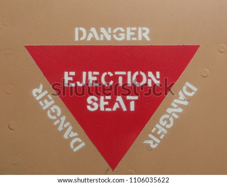 Ejection seat warning sign on fuselage background Royalty-Free Stock Photo #1106035622