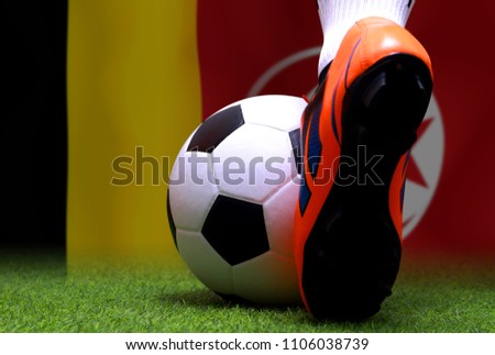 Close up legs and feet of soccer player or football player walk on green grass ready to play match national Belgium and national Tunis.