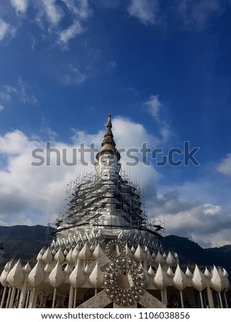 buliding of buddha stautes with blue sky and mountain background