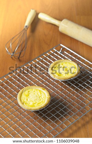 Egg tarts on cooling rack. Wooden background. Portuguese Egg Tarts, is a kind of custard tart found in various Asian countries.Copy space.
