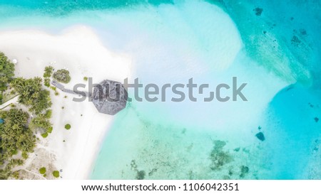 Aerial top view tropical island white sand beach with blue lagoon in Maldives island, Beautiful tropical maldives resort hotel. Royalty-Free Stock Photo #1106042351