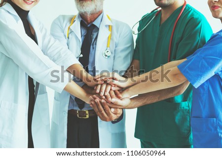 Group of happy doctor surgeon and nurse putting their hands together for teamwork in meeting on white background, Healthcare and medical concept