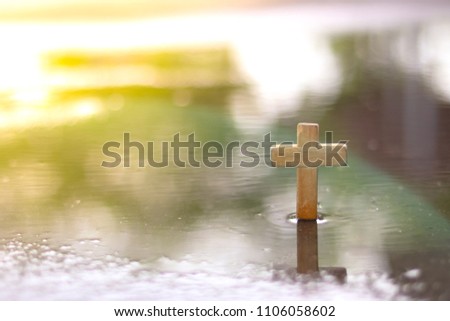 Wooden christian cross is standing in the water. Christianity symbol. Faith hope love concept. Royalty-Free Stock Photo #1106058602