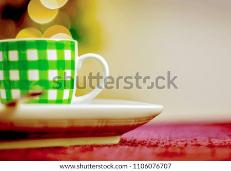 white coffee cup with green stripes with a bokeh effect in the background