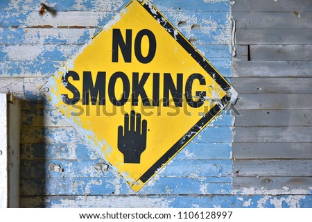 An image of an old yellow no smoking sign.
