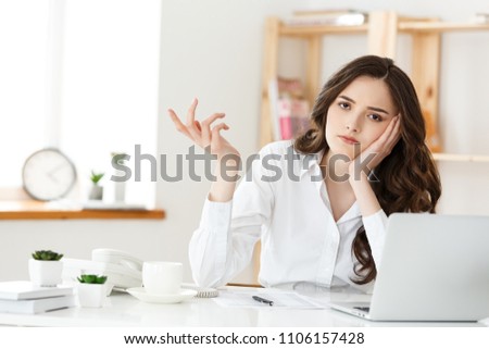 thoughtful woman with hand under chin bored at work, looking away sitting near laptop, demotivated office worker feels lack of inspiration, no motivation