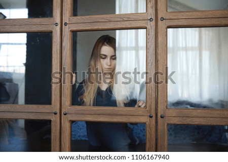 A young girl in a home setting is resting in a big apartment
