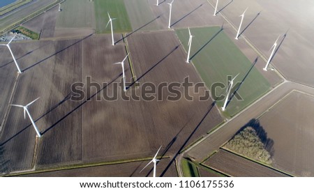 Aerial top down photo of wind farm a group of wind turbines in the same location used to produce electricity pruducing sustainable renewable energy provided by national recources