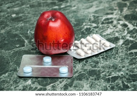Take pictures of pills and healthy red apples
