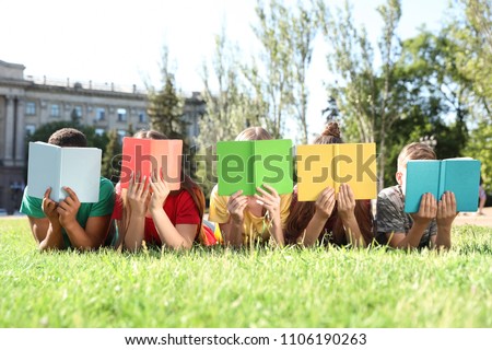 Group of children with books outdoors. Summer camp