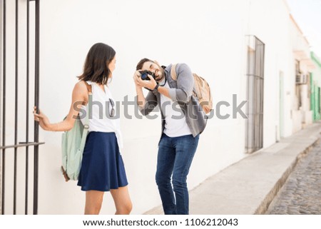 Handsome boyfriend clicking a picture with camera of beautiful girlfriend