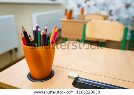 Color pencils in glass on desk with shallow depth of field