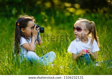 Two children girl(female, woman) hold a camera take a picture each other(together) with smile(happy)