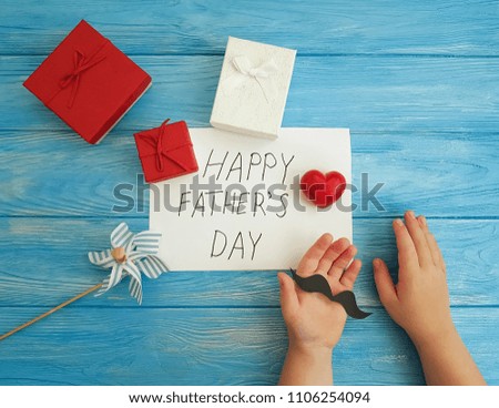father's day, baby's hands, red heart on a blue wooden background