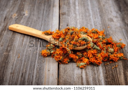 Dried calendula flowers on wooden background. Medicinal plants.