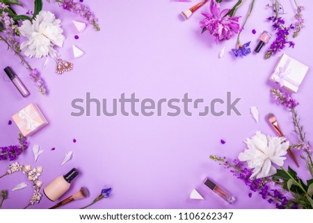 Set of cosmetics, brushes and jewellery with fresh flowers on purple background. Presents for summer sale. Shopping