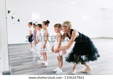 Group of beautiful little girls practicing ballet at dancing class.
