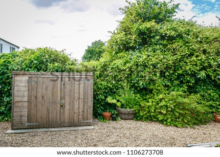 View of a nice English garden with a small wooden hut and a lot of vegetation