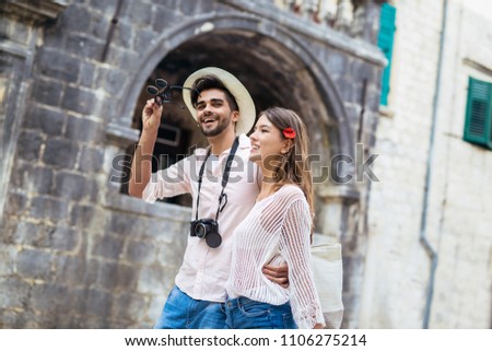 Traveling couple of tourists walking around old town. Vacation, summer, holiday, tourism: concept.