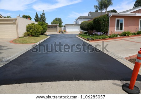 Private drive way, street rehabilitation and slurry seal project finished with crews expertly applying the slurry seal. Re-surfaced Cul-de-sac shown with unidentifiable crew working


 Royalty-Free Stock Photo #1106285057