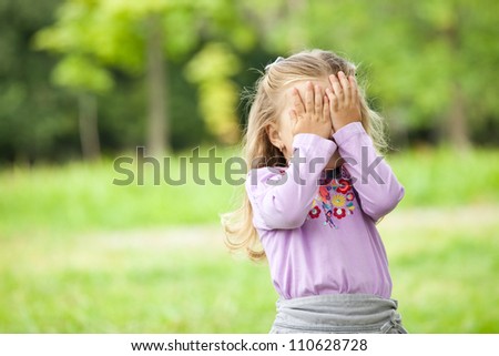 Little girl hiding face outdoor portrait Royalty-Free Stock Photo #110628728