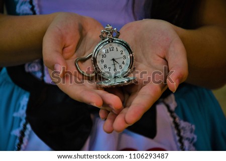 Pocket watch in the palm of the girl's hand