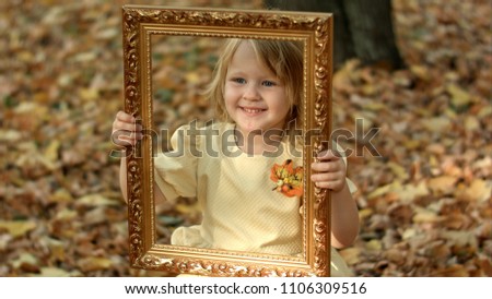 Girl posing with picture in autumn park