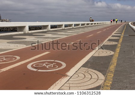 Bicycle red lanes next to pedestrian sidewalk on the coast in Las Palmas, Spain. Outdoors activity, healthy environment, going green concern, pollution reduction concept